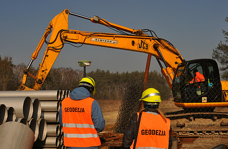 two men standing near excavator thumbnail