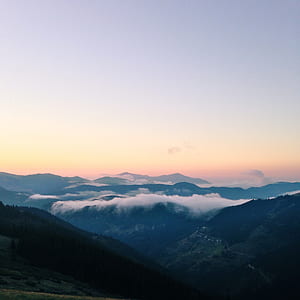 aerial photography of mountains covered with fogs under orange and white cloudy skies thumbnail