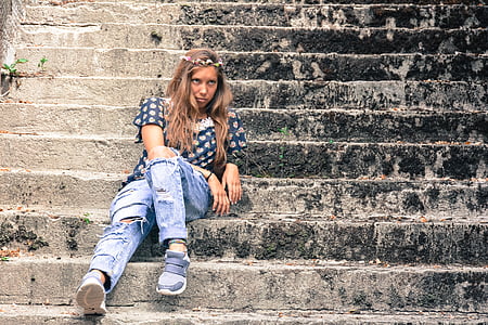 woman in black and white shirt sitting on concrete stair thumbnail