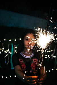 Woman Holding Sparkle during Nighttime thumbnail