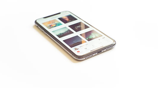 turned on silver iPhone X on white surface thumbnail