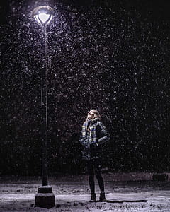 woman standing in front of street light during winter season thumbnail