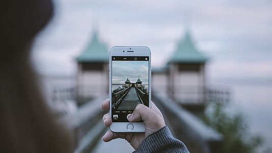 shallow focus photography of person taking a picture of establishment thumbnail