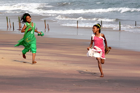 two girls on sand near shoreline thumbnail