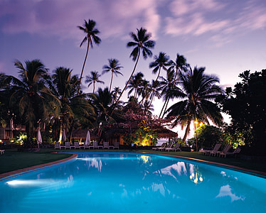 outdoor pool with trees during night time thumbnail