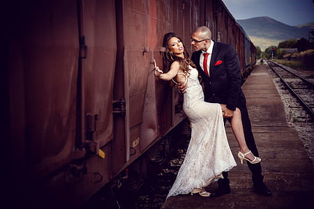man and woman standing beside train thumbnail