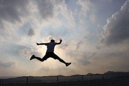 silhouette of man jumping on air under cloudy sky thumbnail