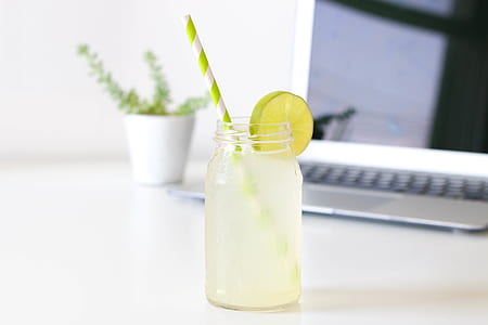 glass of citrus juice with disposable straw thumbnail