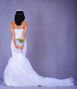 woman holding flower bouquet facing on wall thumbnail