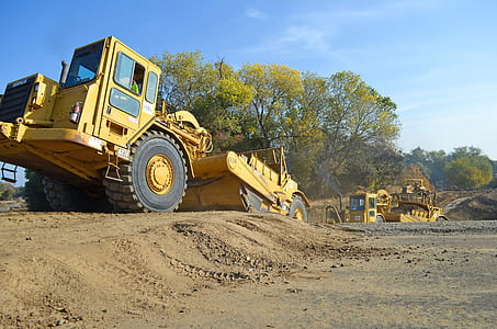 yellow haul truck near green trees thumbnail