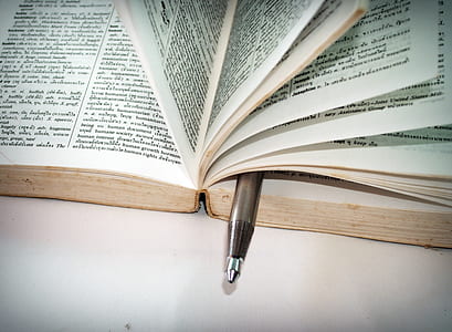 White Ballpoint Pen on Book Pages thumbnail