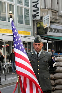 man holding USA flag near building during daytime thumbnail