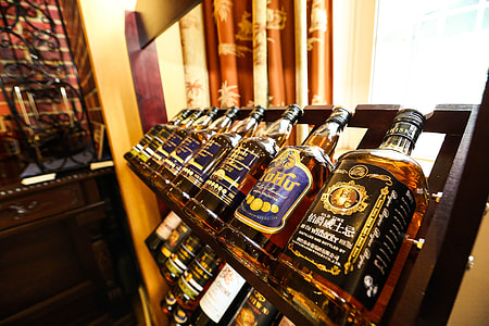 assorted-brand bottles on brown wooden rack thumbnail