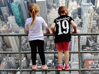 two girls standing on gray metal railing thumbnail