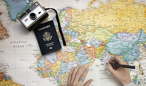 Concept photo with world travel theme. Person planning trip with world man, camera and passport. thumbnail