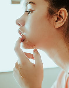 woman touching her lips with one finger thumbnail