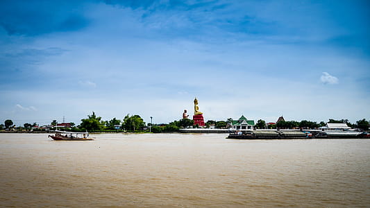 Buddha Statue in Thailand sits at river edge thumbnail