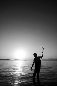 silhouette of person holding sickle thumbnail