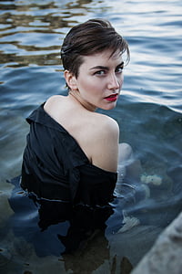 woman wearing black long-sleeved top sink her half body on water during daytime thumbnail