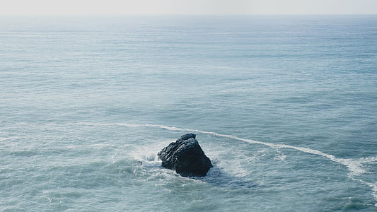 black rock formation in body of water thumbnail