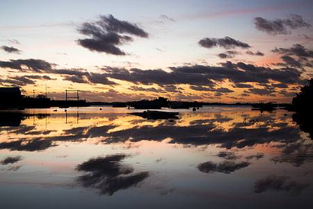 silhouette of boat under white clouds during sunset thumbnail