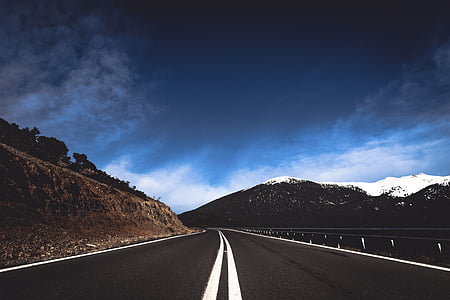empty road leading to snow covered mountain thumbnail