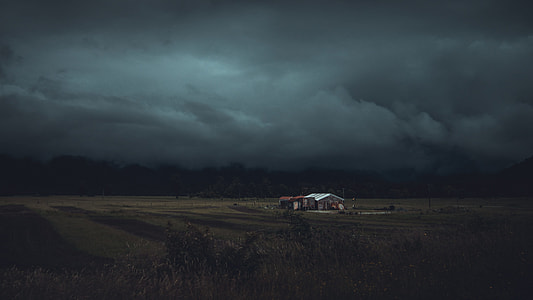 brown house in the middle of a grass field thumbnail