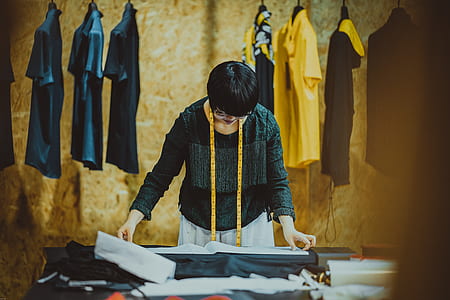 woman touching cloth in front of clothes thumbnail