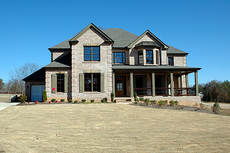 gray concrete 2-storey house near tress under blue sky thumbnail