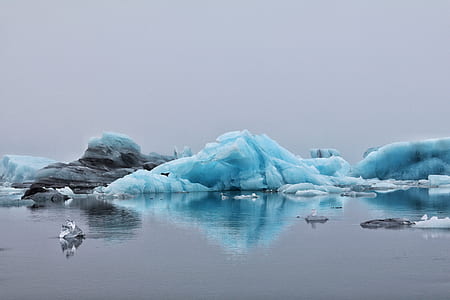ice and rock reflecting on calm water thumbnail