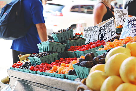 Man Wearing Blue Top and Black Bottom Standing Near Fruit Stand thumbnail