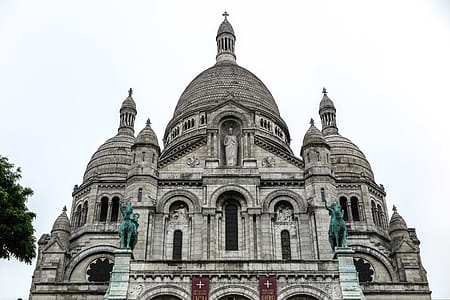 Grey stone and bronze statues form the front of the Sacre Coeur in Paris, France. thumbnail