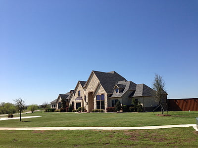 landscape photography of gray house near bare trees during daytime thumbnail