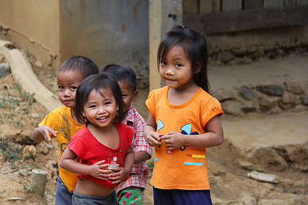 smiling girl in red shirt standing next to girl in yellow shirt and two boys thumbnail