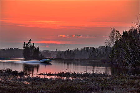 white speedboat on body of water at sunset thumbnail