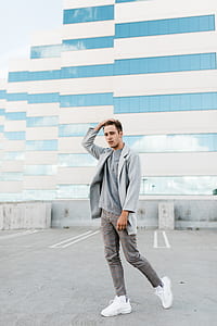 man holding his head standin near building thumbnail