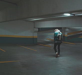 man in white and black backpack walking in parking lot thumbnail