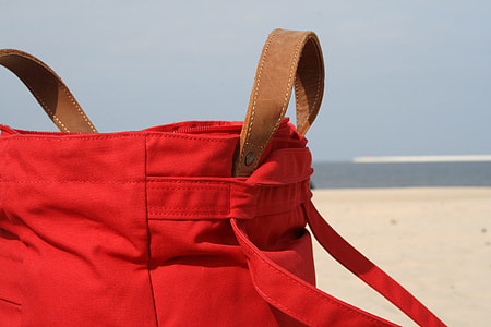 red and brown crossbody bag during daytime thumbnail