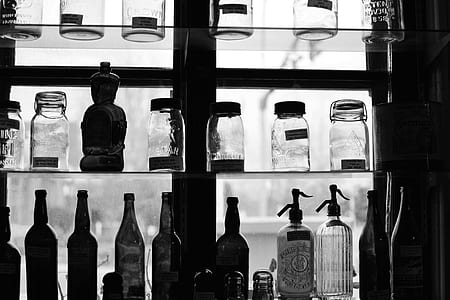 grayscale photography of bottles on shelf thumbnail