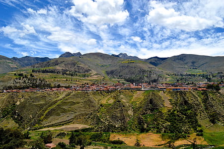Birdseye Photography of Buildings Near Hills and Trees Under Blue Sky thumbnail