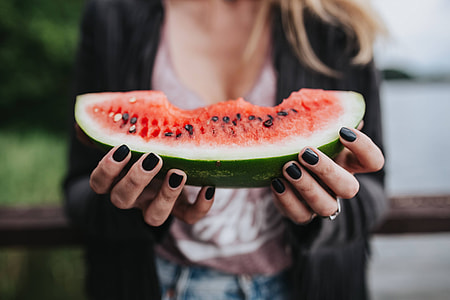 Blonde woman having a healthy snack at the wooden pier thumbnail
