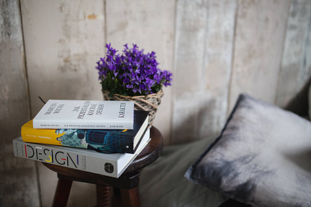 Books and purple flowers on a wooden stool by the bed thumbnail
