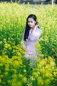 woman holding her left ear while standing in flower farm thumbnail