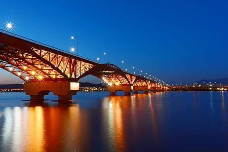 photo of calm body of water under bridge with lights at night thumbnail