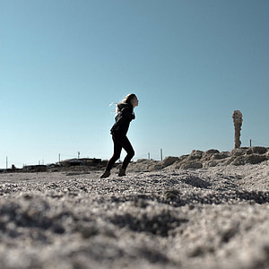 woman in black jacket and skinny jeans walking uphill thumbnail