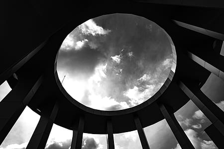 Grayscale Photo of a Round Building With Hole thumbnail