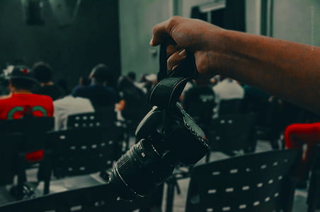 person holding DSLR camera thumbnail