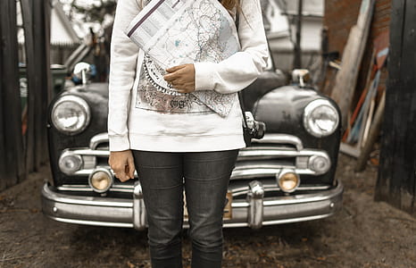 person holding a map while standing in front of a car thumbnail