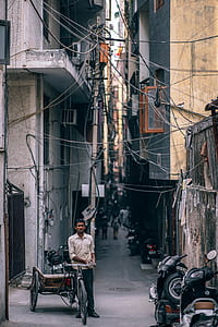 man leaning on trike under electricity cables thumbnail