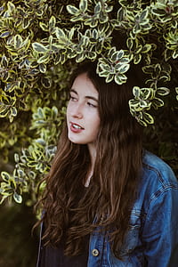 woman in blue denim jacket near green plants thumbnail